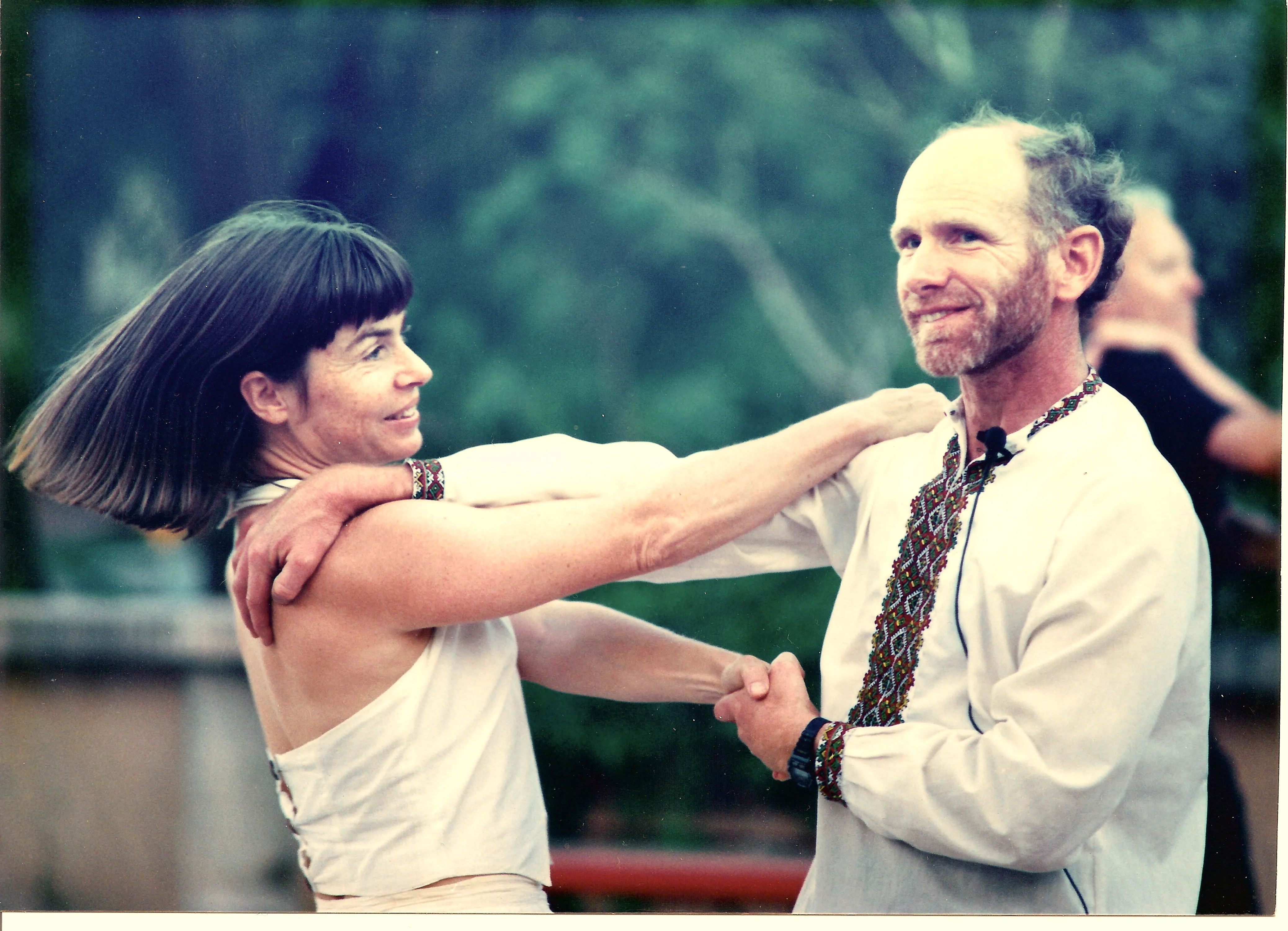 Two ballroom swing dancers dancing under lights.